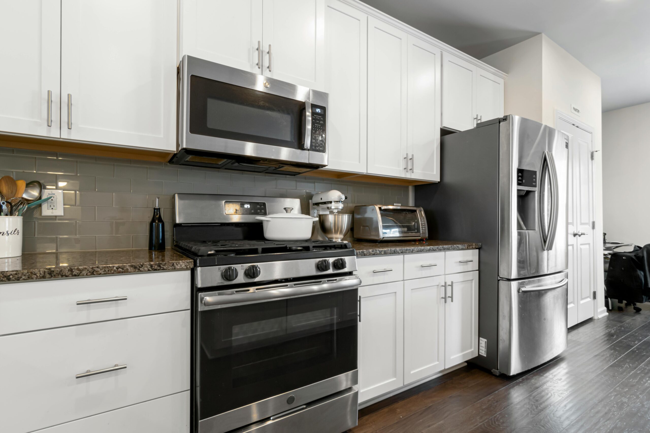 Sleek kitchen featuring contemporary white cabinets and stainless steel appliances.