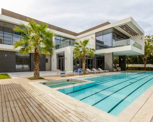 Explore this luxurious modern villa in Dubai with a stunning swimming pool and palm trees.