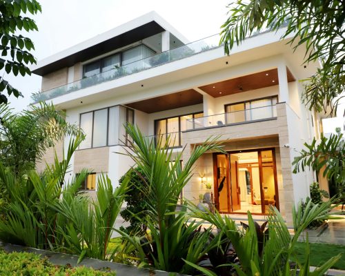 A modern luxury villa surrounded by lush greenery, showcasing contemporary architectural design.